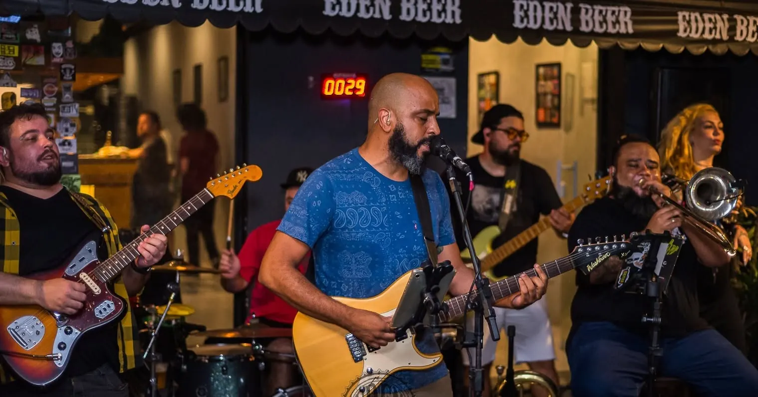 Os cinco músicos da Violeta Genciana tocando na Eden Beer: guitarras, baixo, bateria e trombone
